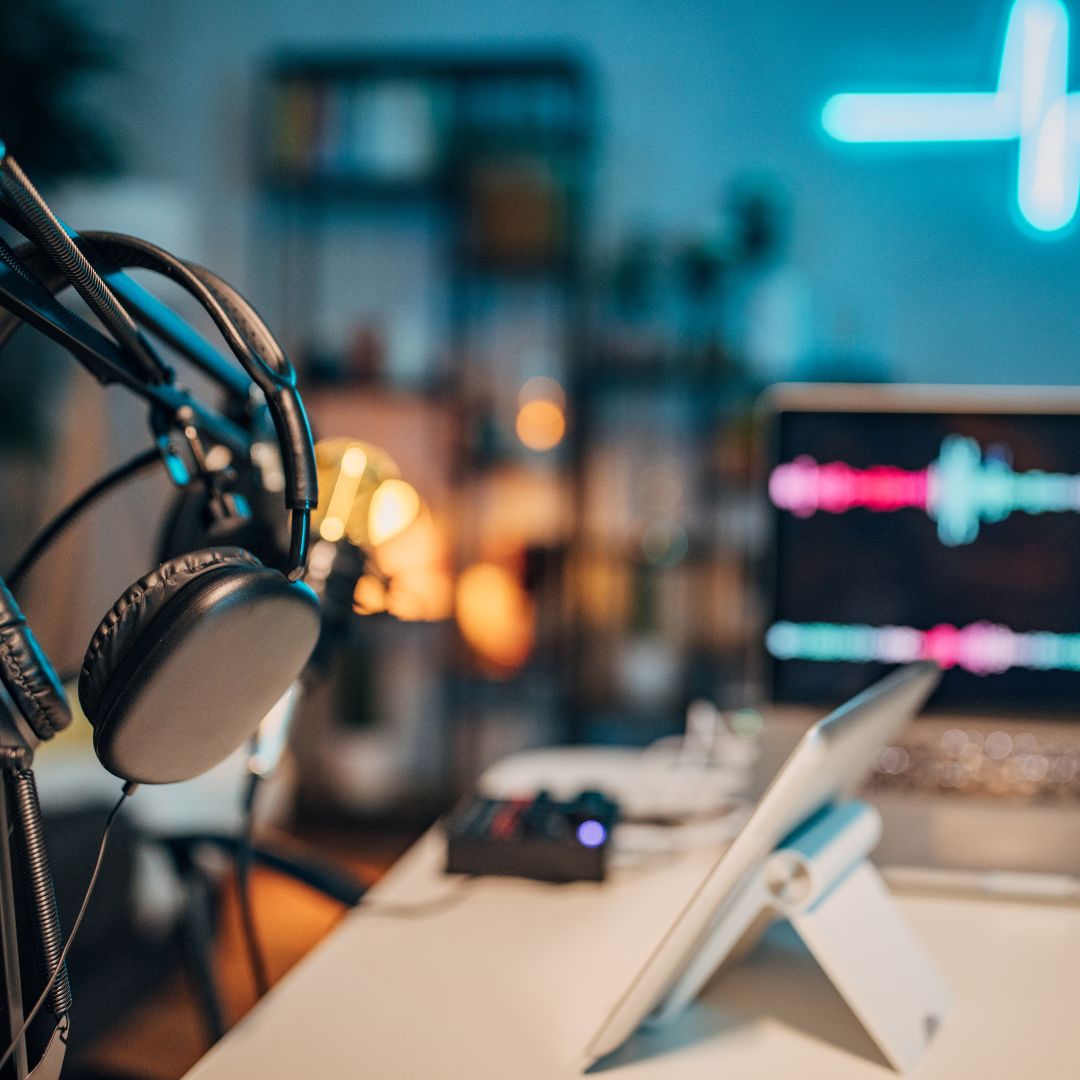 Headphones, laptop, and equipment in AMPED Leadership Podcast studio.