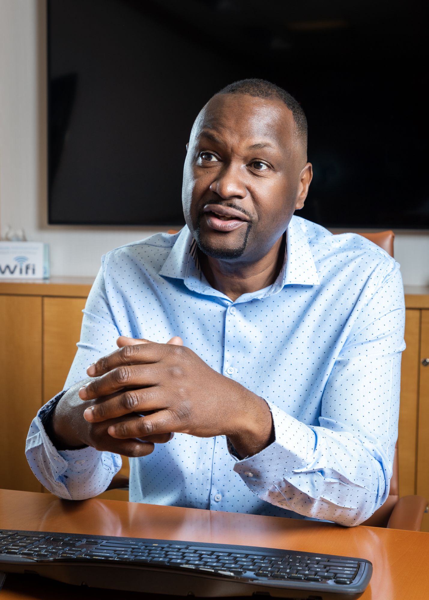 Dr. Kevin John sitting at a table hosting a leadership mastermind group. 