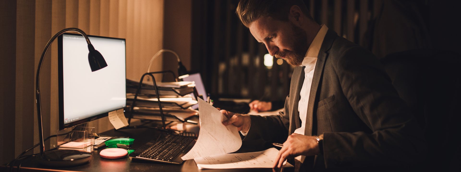 Male leader sitting at his desk going over reports.